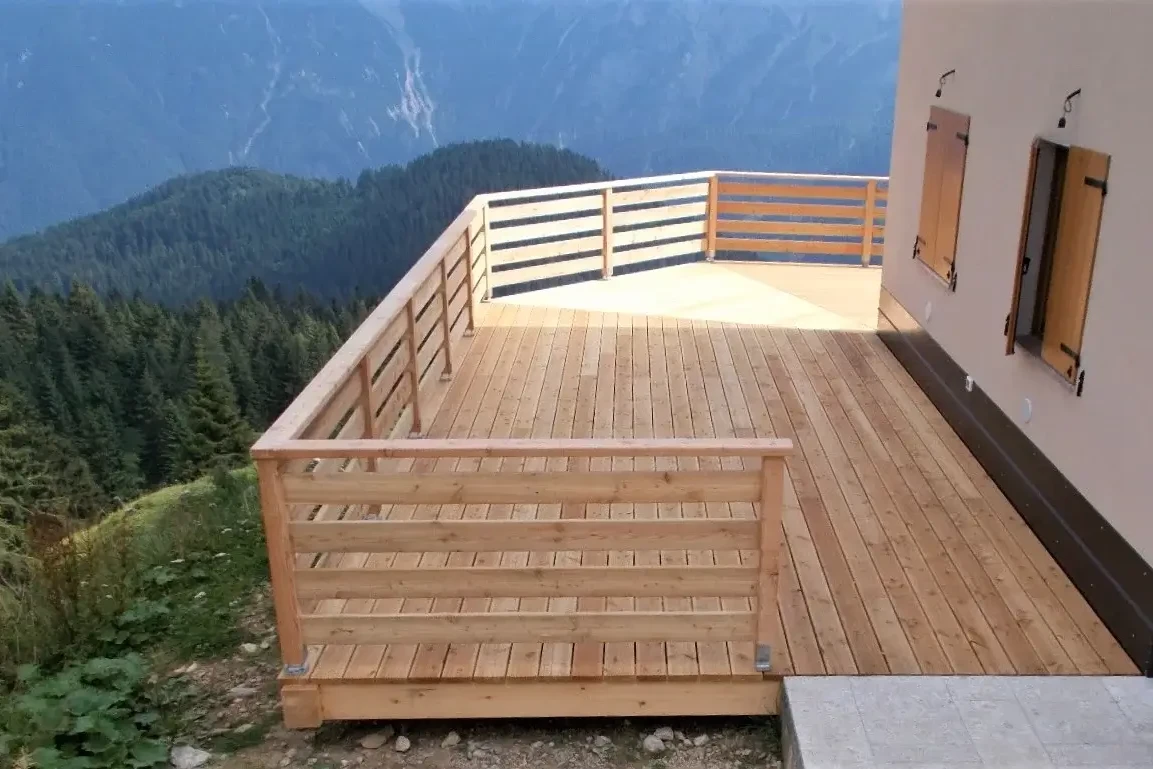 pavimentazione e recinzione in legno di larice su terrazza in malga