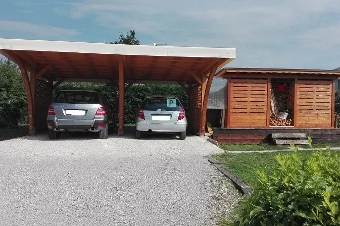 tettoia in legno per auto con tetto a una falda e grigliato ai lati