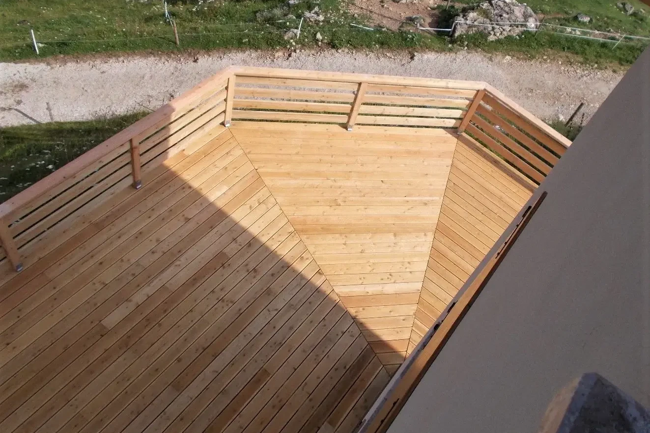 pavimentazione in larice con recinzione in legno per la terrazza di una malga