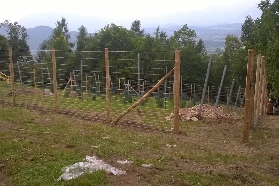 recinzione con rete e pali in legno