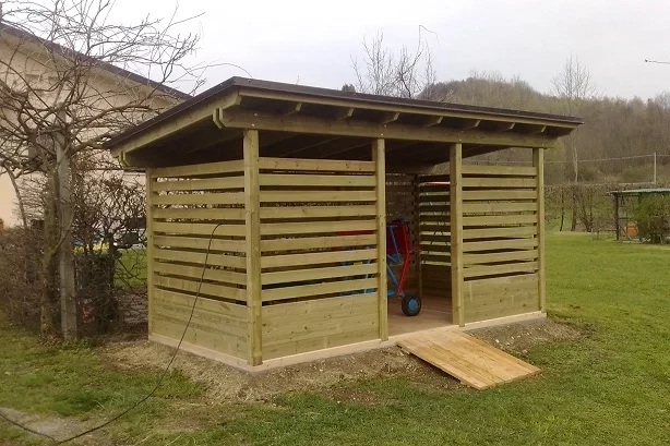 legnaia in legno con tavole intervallate e rampa d'ingresso