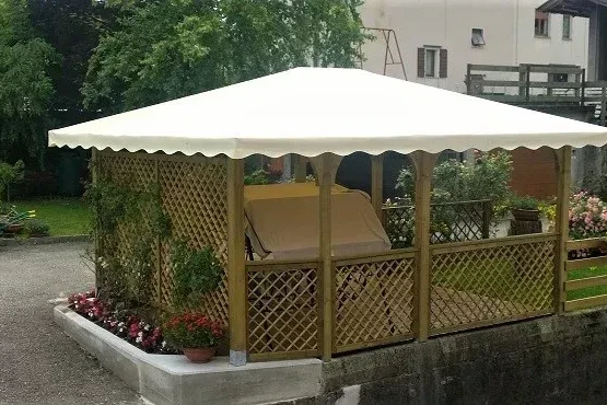 pergola in pino nordico con tetto a quattro falde con telo