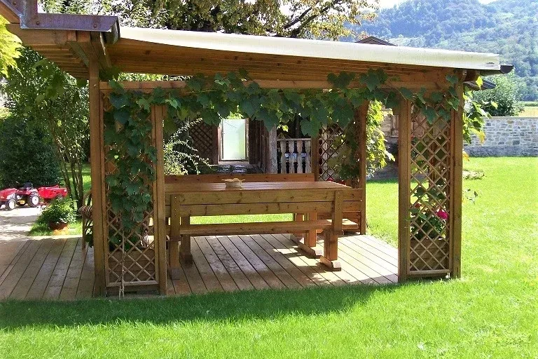 pergola in pino nordico con grigliati e fioriere ad angolo