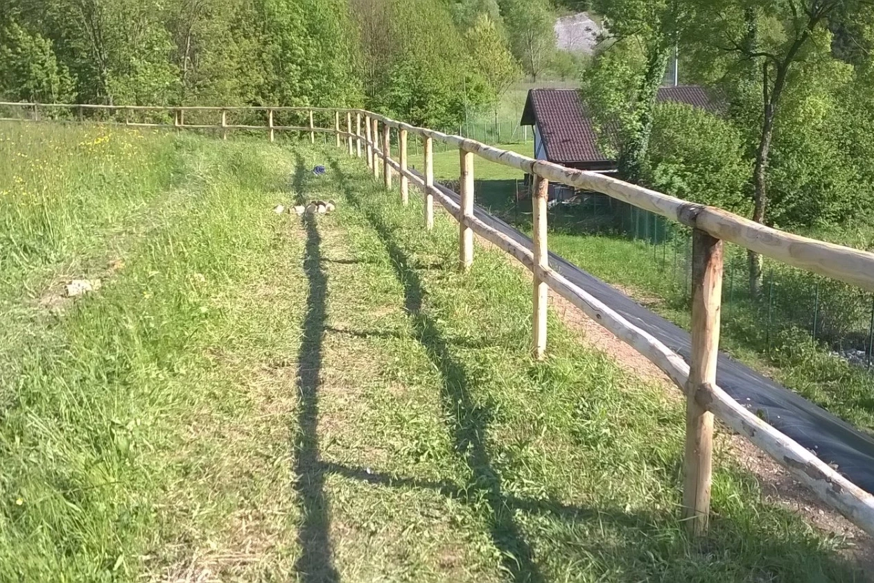 recinzione in legno con corrimano e una fila di pali